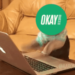 Person with Green OK Sticker on Face at Laptop