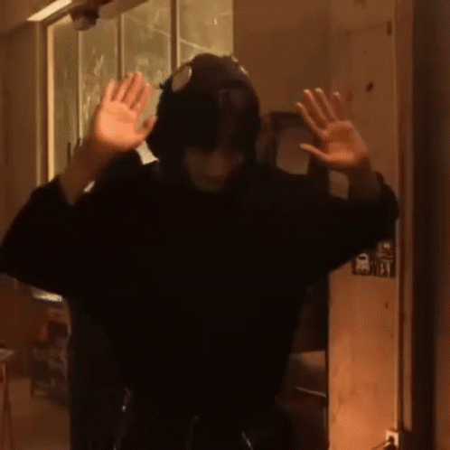 Person with Hat and Headphones in Dark Room