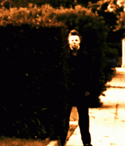 Person With Mask Walking Down Sidewalk GIF