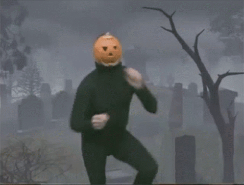 Person With Pumpkin on Head Dancing in Cemetery