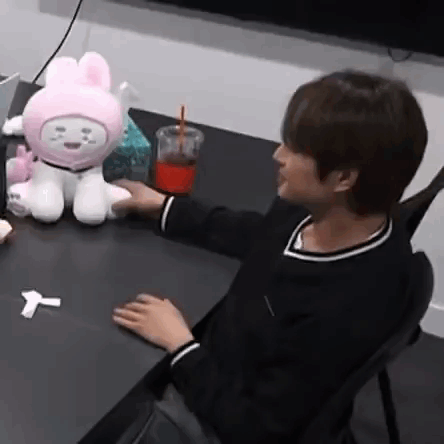 Person With Stuffed Animal and Drink at Table