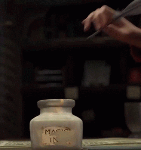 Person Writing With Feather In Magic Ink Jar GIF