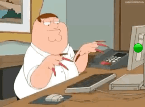 Peter Griffin From Family Guy Is Sitting At A Desk With A Computer And A Mouse . GIF