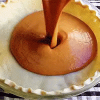 Pie Crust Being Filled With Caramel Sauce