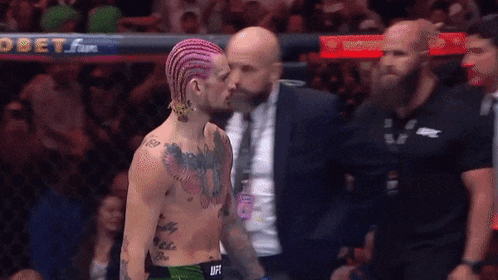 Pink Hair Man Talking to Suit Man at Obet Sign