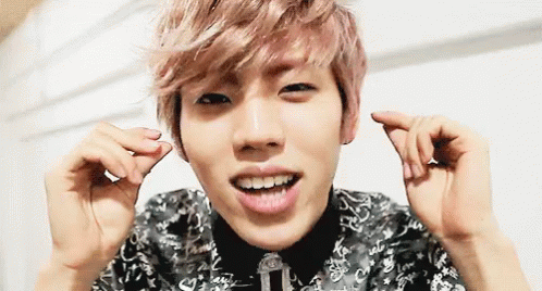 Pink-Haired Man Making Heart Shape and Smiling