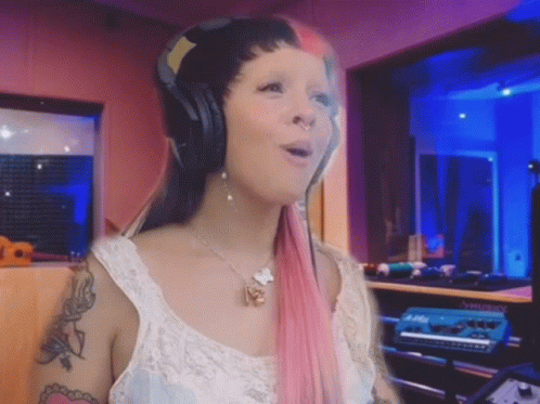 Pink-Haired Woman Singing into Microphone with Headphones