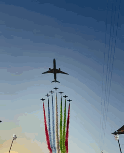 Plane Flying Over Row Of Planes With Smoke Trails GIF