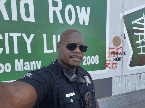 Police Officer Selfie With Green Kid Row Sign GIF
