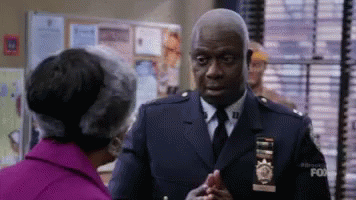 Police Officer Shaking Hands With Woman In Purple Coat GIF