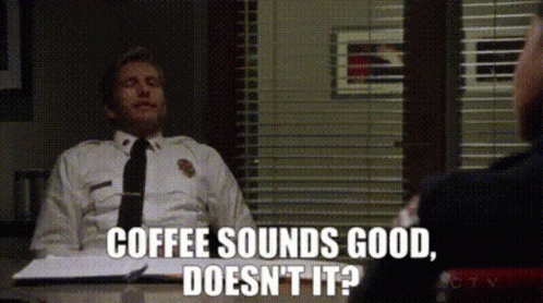 Police Officer Sitting at Desk Saying Coffee Sounds Good Doesn't It