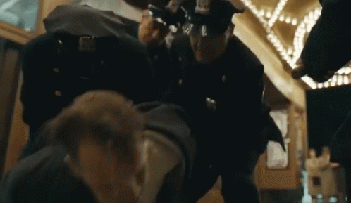 Police Officers Standing Around Man GIF