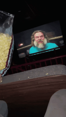 Popcorn Bag Poured In Front Of Bearded Man GIF