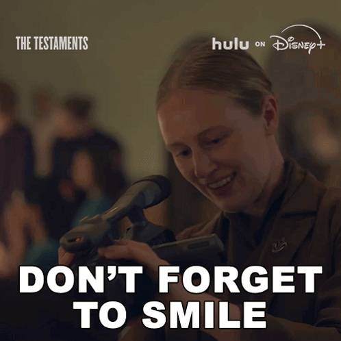 Poster Woman Holding Camera Says Don't Forget To Smile GIF