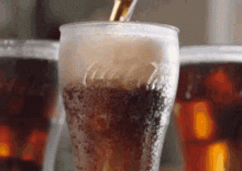 Pouring Cola Into Glass With Ice