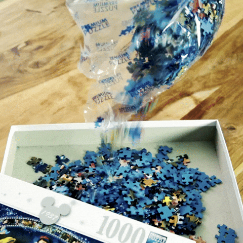 Pouring Jigsaw Puzzle Pieces Into Box GIF