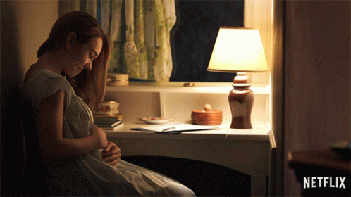 Pregnant Woman Sitting at Desk With Lamp and Netflix Logo