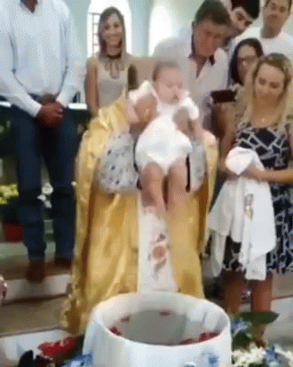 Priest Holding Baby at Baptism