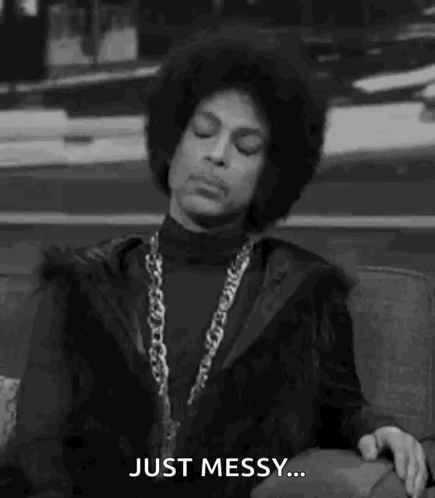 Prince Is Sitting On A Couch In A Black And White Photo And Saying `` Just Messy '' . GIF