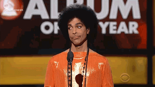 Prince Is Standing In Front Of A Microphone At An Album Of The Year Awards GIF