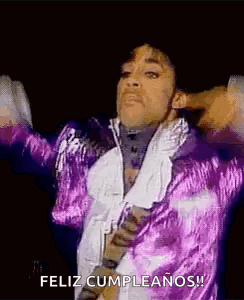 Prince Is Wearing A Purple Jacket And Tie And Is Dancing On Stage . GIF