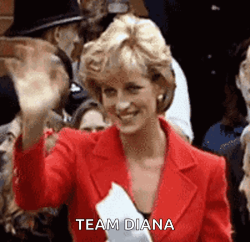 Princess Diana Is Wearing A Red Jacket And Waving At The Camera While Holding A Piece Of Paper That Says Team Diana . GIF