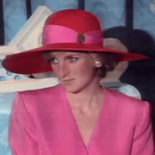 Princess Diana Wearing A Pink Suit And A Red Hat . GIF