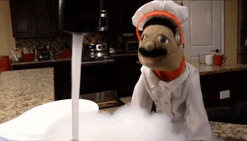 Puppet in Chef Uniform Standing Next to Sink