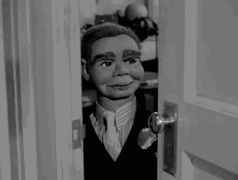 Puppet in Suit Looking Out Doorway