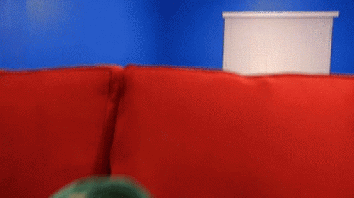 Puppet With Open Mouth On Red Couch GIF