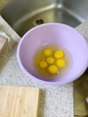 Purple Bowl Filled With Yellow Eggs Beside Sink