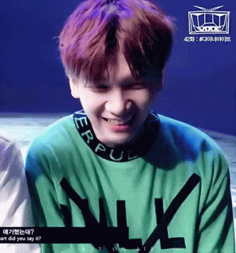 Purple Haired Man Smiling in Green N Sweater
