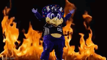 Purple Mascot In Front Of Flames GIF