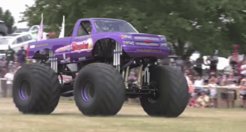 Purple Monster Truck Driving in Front of Crowd