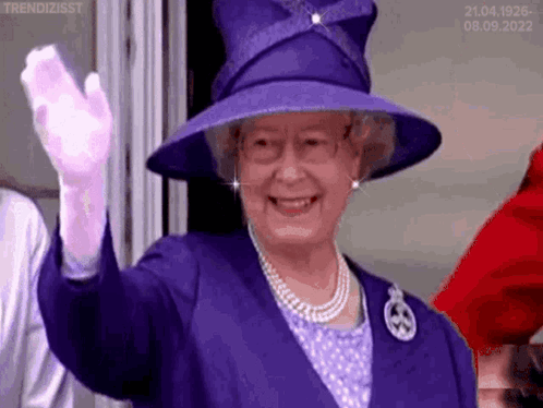 Queen Elizabeth Is Wearing A Purple Hat And Gloves And Waving At The Camera . GIF