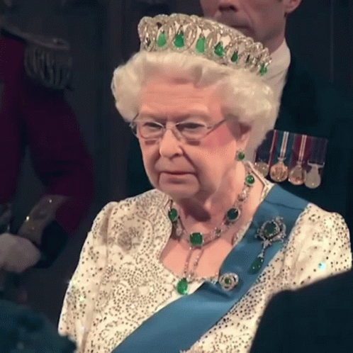 Queen Elizabeth Is Wearing A Tiara And A Blue Sash GIF