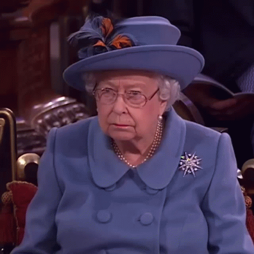 Queen Elizabeth Wearing A Blue Coat And Hat With Feathers GIF