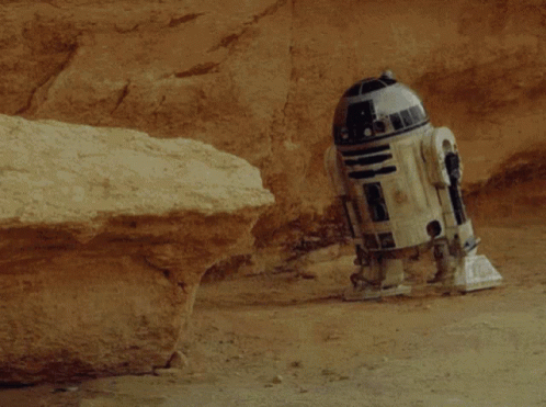 R2D2 Laying In Dirt Near Rock GIF