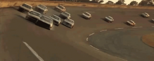 Race Car Driving Down Street With Other Cars GIF