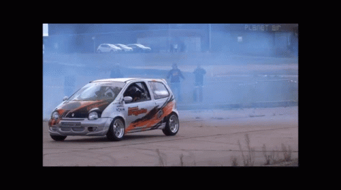 Race Car Driving In Front Of Planet Air Building GIF