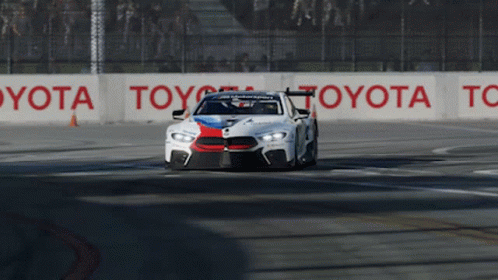 Race Car Driving on Track With Toyota Sign
