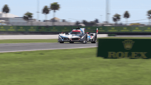Race Car on Track with Rolex Sign