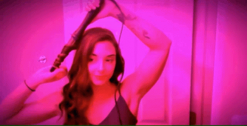 Woman Curling Her Hair Ready To Party GIF