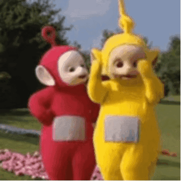 Red And Yellow Teletubbies Standing In Grass GIF