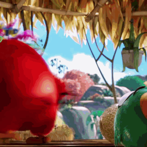 Red Angry Bird Standing Next to Green Bird