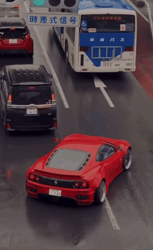 Red Car Driving Next to Bus