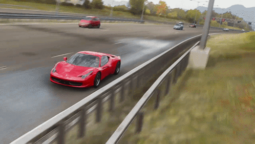 Red Car Driving on Highway Beside Fence