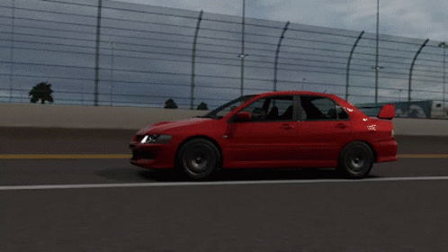 Red Car Driving on Highway With Fence