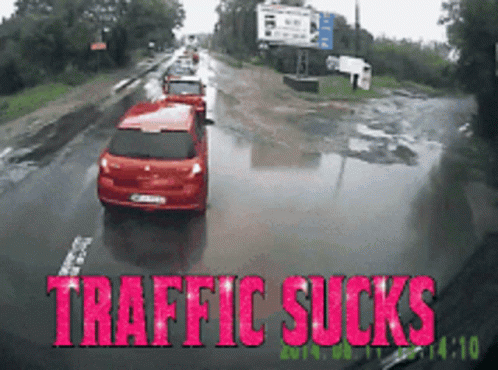 Red Car Driving on Wet Road Traffic Sucks