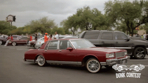 Red Car Parked in Front of Donk Contest Sign